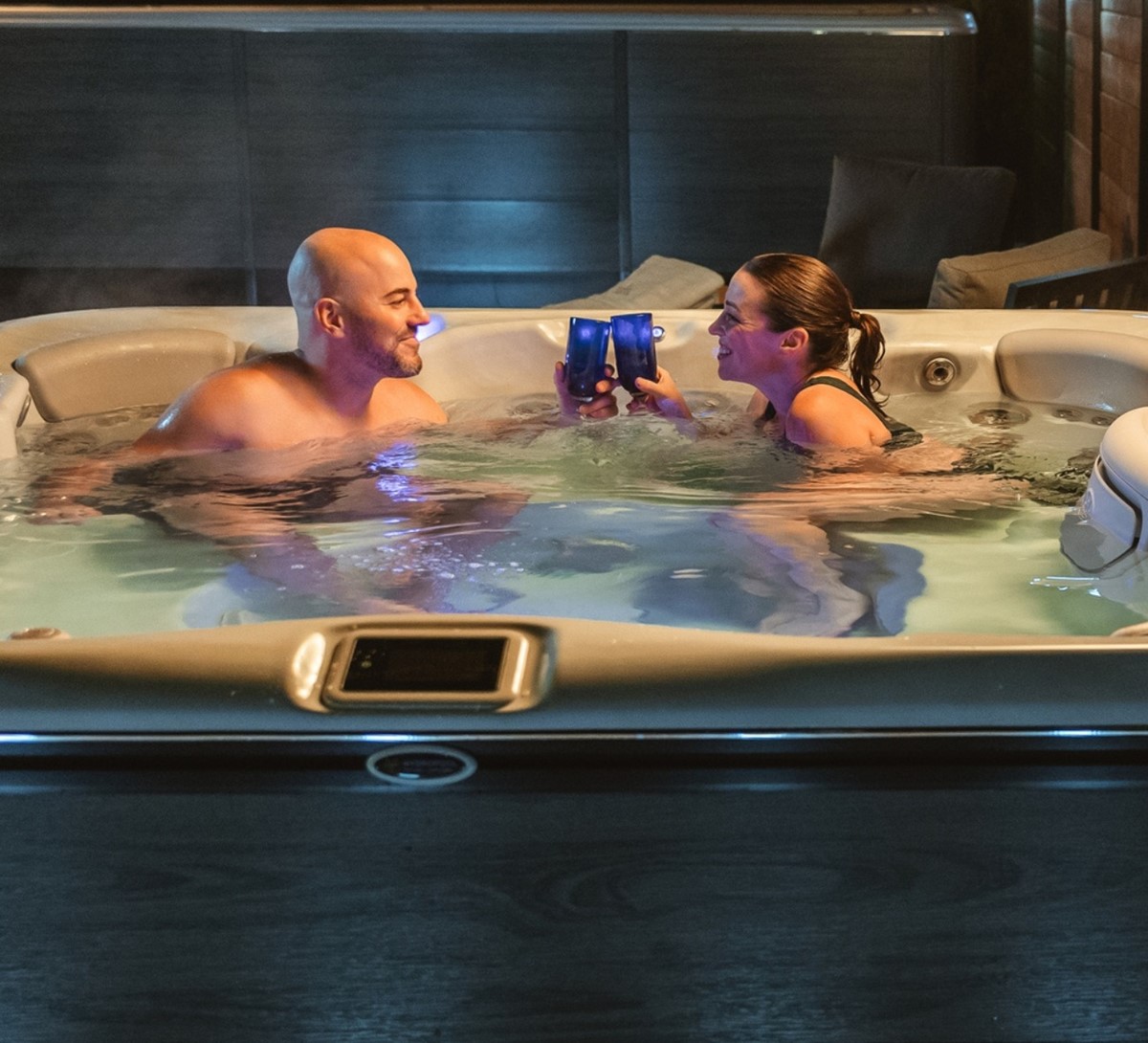 Par som njuter i Hydropool spabad med belysning – premium utomhusspa för avkoppling året runt.