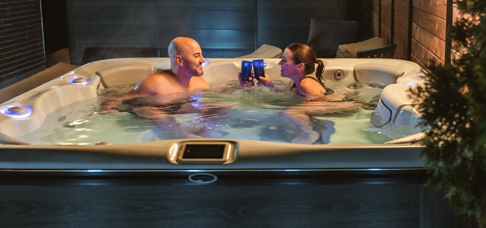 Par som njuter i Hydropool spabad med belysning – premium utomhusspa för avkoppling året runt.